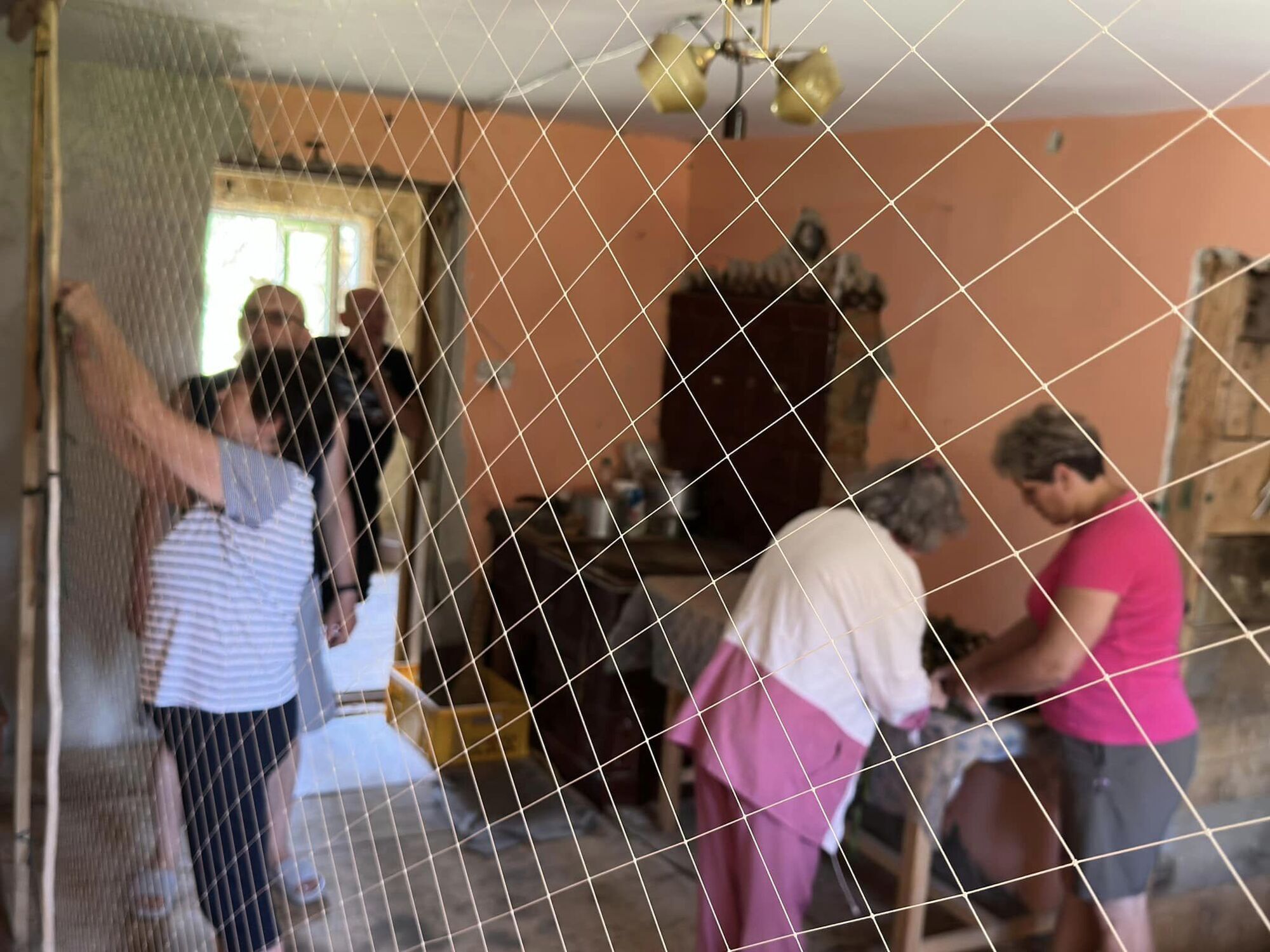 У селі Велика Рожанка волонтери плетуть сітки у приватному будинку